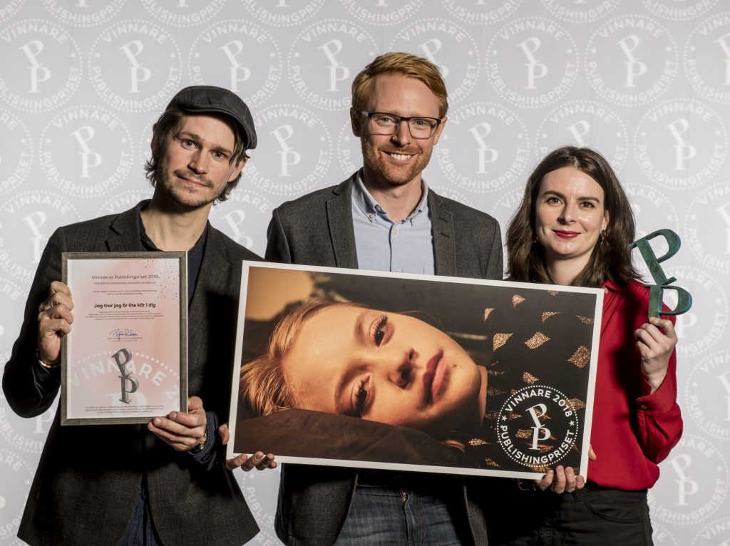 Filmens manusförfattare, producent och regissör poserar med publishingpriset